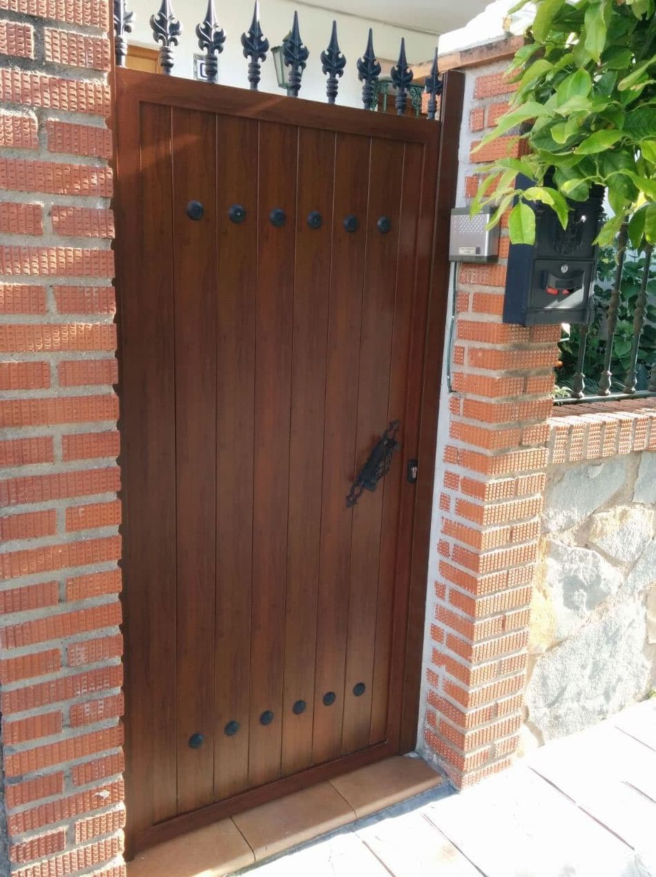 Puertas peatonales de hierro pintadas con acabado imitación madera